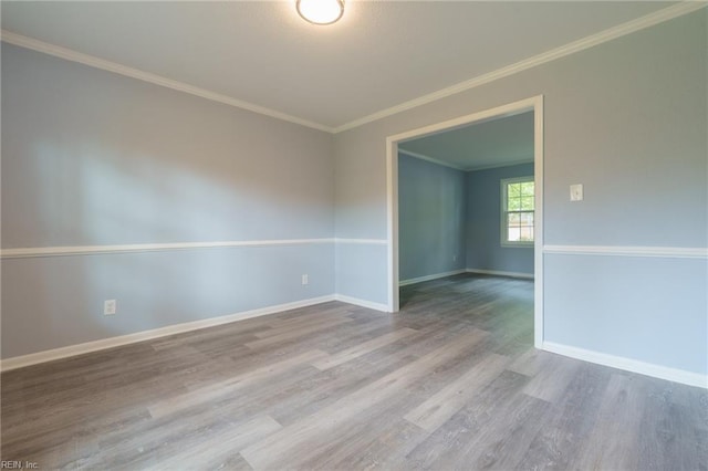 spare room with wood-type flooring and ornamental molding