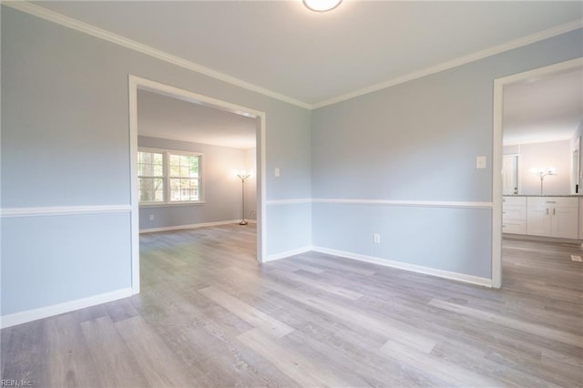 empty room with light hardwood / wood-style floors and ornamental molding