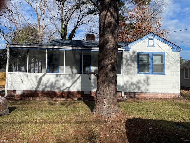 view of front of home with a sunroom and a front yard