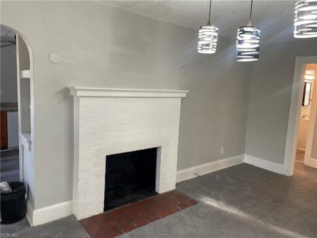 unfurnished living room with a stone fireplace, a textured ceiling, and dark colored carpet