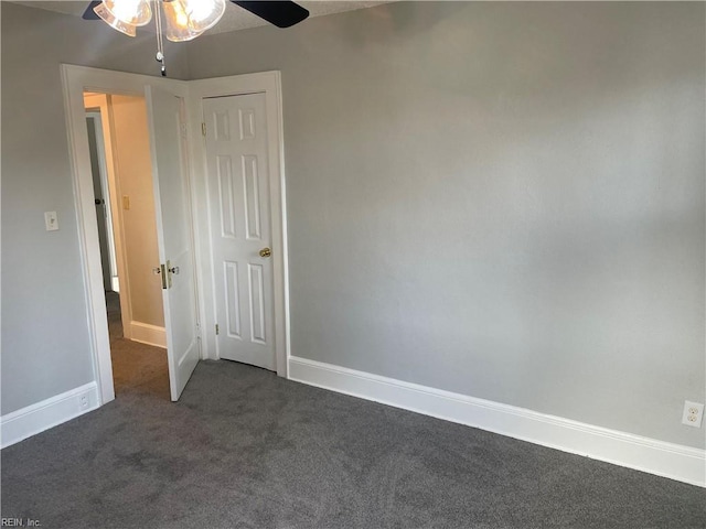 unfurnished bedroom with ceiling fan and dark colored carpet