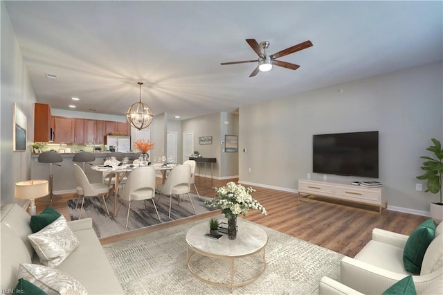 living room featuring hardwood / wood-style floors and ceiling fan with notable chandelier