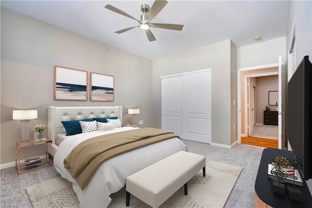 carpeted bedroom featuring ceiling fan and a closet