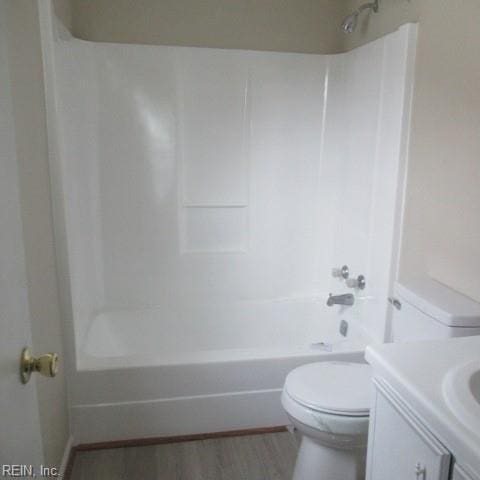 full bathroom with hardwood / wood-style floors, vanity, toilet, and tub / shower combination