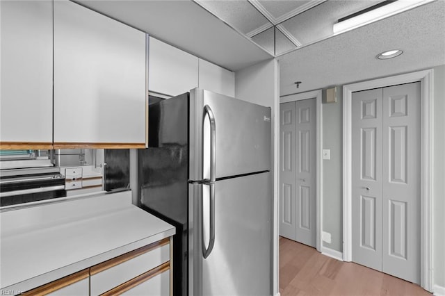 kitchen with white cabinetry, stainless steel fridge, and light wood-type flooring