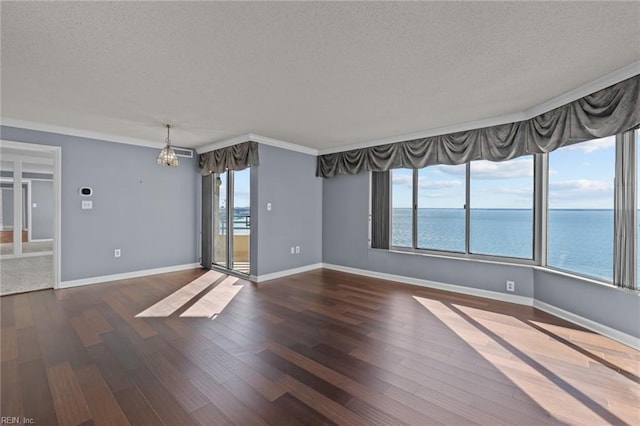 empty room featuring dark hardwood / wood-style flooring, a textured ceiling, a water view, and ornamental molding