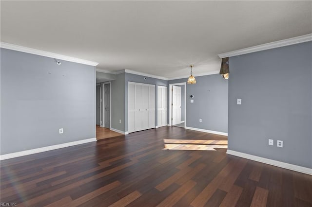 spare room with crown molding and dark wood-type flooring