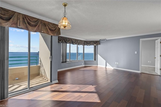 empty room featuring hardwood / wood-style flooring, plenty of natural light, and a water view