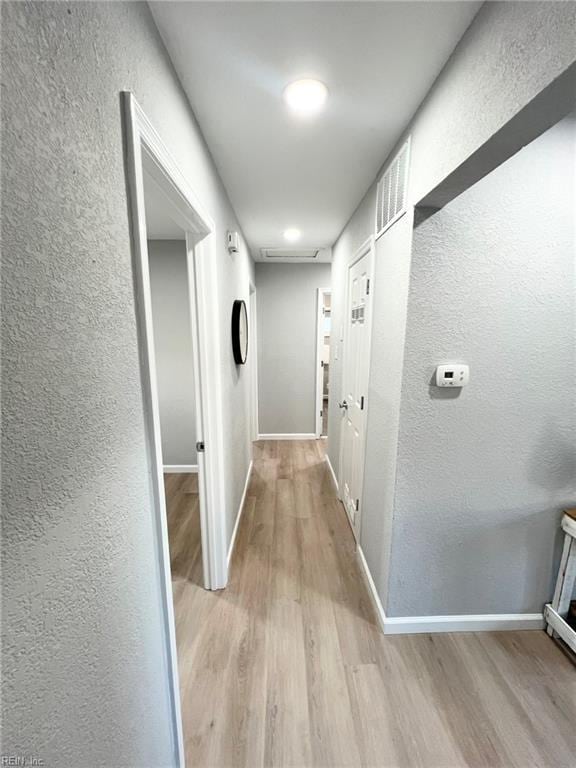 hallway with light hardwood / wood-style flooring