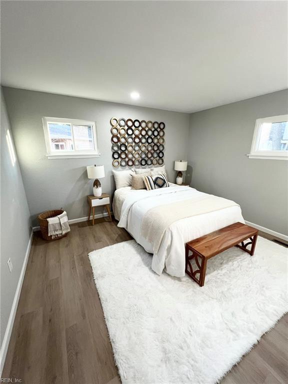 bedroom with dark wood-type flooring and multiple windows