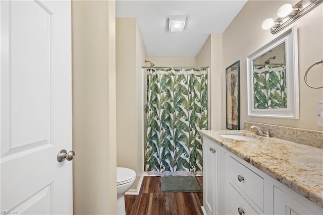 bathroom featuring a shower with curtain, hardwood / wood-style floors, vanity, and toilet