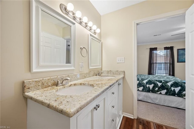 bathroom featuring vanity, wood-type flooring, and ornamental molding