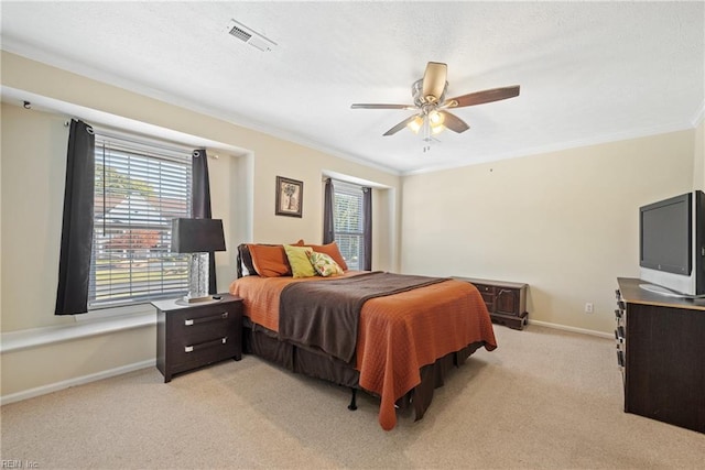 carpeted bedroom with ceiling fan and crown molding