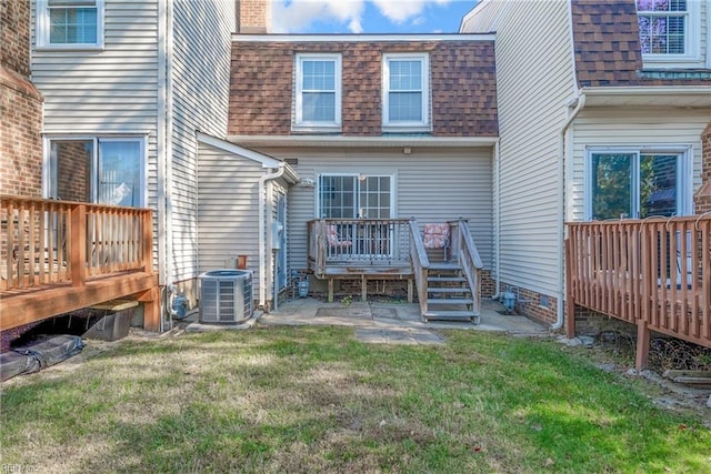 rear view of house featuring cooling unit, a lawn, and a wooden deck