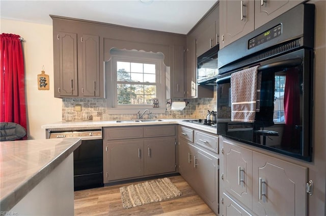 kitchen featuring light wood-type flooring, sink, gray cabinets, and black appliances