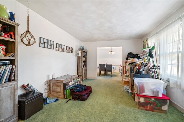 misc room with a notable chandelier and carpet floors