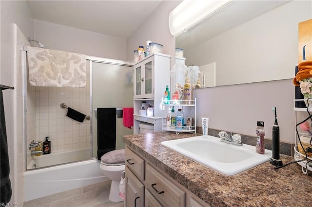 full bathroom with tile patterned flooring, vanity, toilet, and bath / shower combo with glass door