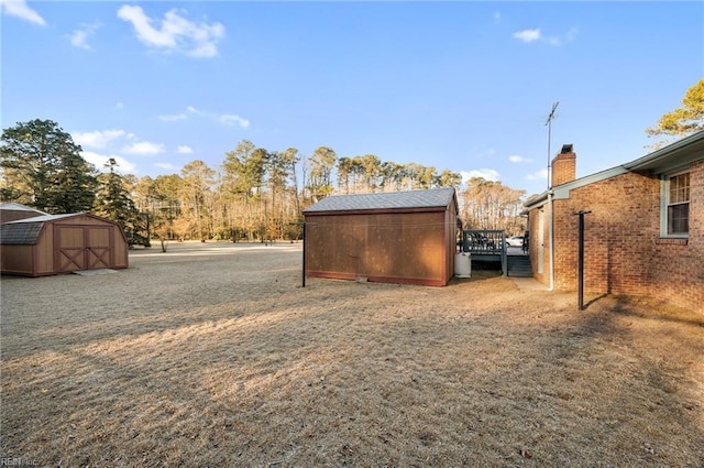 view of yard with a deck and a storage shed