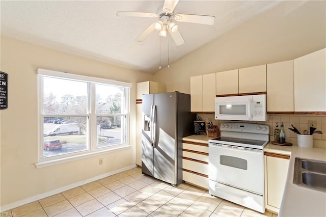 kitchen featuring white appliances, vaulted ceiling, ceiling fan, white cabinetry, and light tile patterned flooring