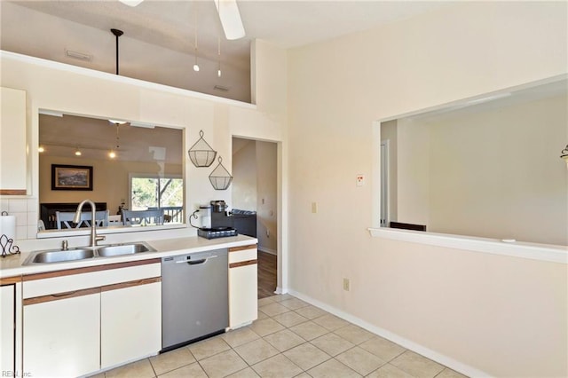 kitchen with stainless steel dishwasher, ceiling fan, sink, light tile patterned floors, and white cabinetry