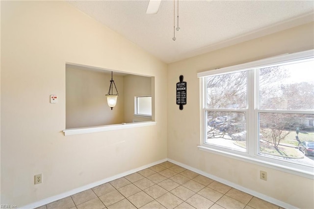 unfurnished room with tile patterned floors, plenty of natural light, and vaulted ceiling