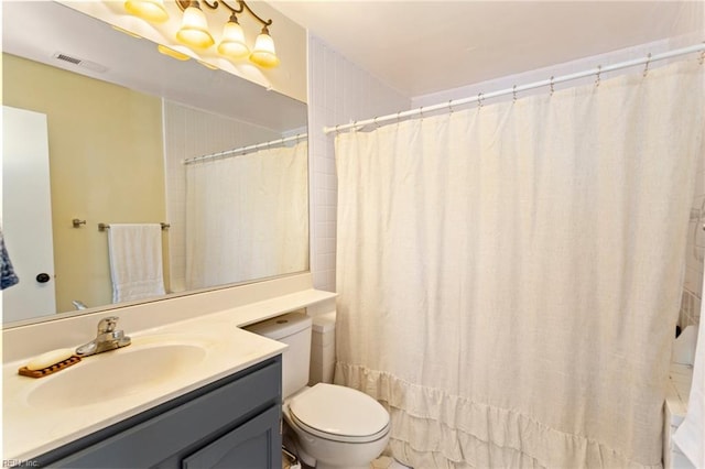 bathroom with walk in shower, vanity, and toilet