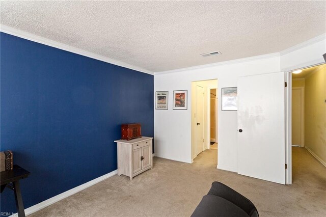 interior space featuring a textured ceiling, light colored carpet, and ornamental molding