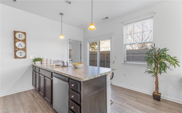 kitchen with sink, hanging light fixtures, stainless steel dishwasher, light wood-type flooring, and kitchen peninsula