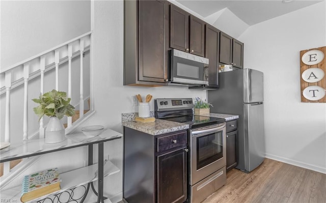 kitchen with dark brown cabinets, light wood-type flooring, and stainless steel appliances