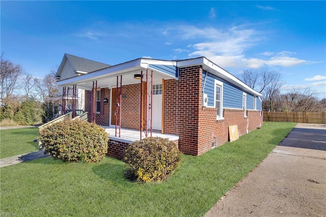 view of side of home with a lawn and a porch