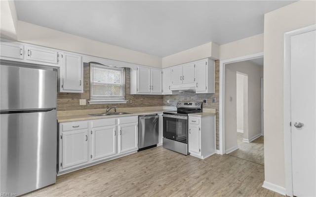 kitchen featuring sink, decorative backsplash, light hardwood / wood-style floors, white cabinetry, and stainless steel appliances