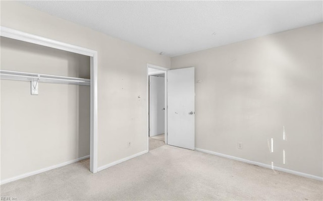 unfurnished bedroom featuring light carpet and a closet