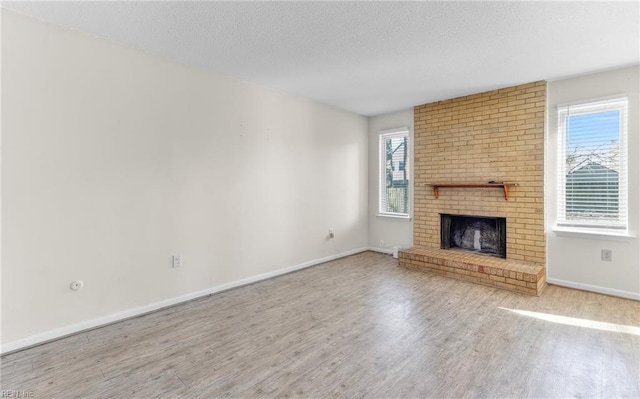 unfurnished living room featuring a fireplace, hardwood / wood-style floors, and plenty of natural light