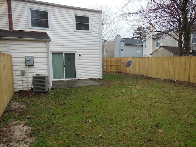 rear view of property featuring central AC unit and a yard