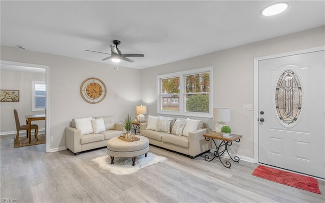 living room featuring ceiling fan and light hardwood / wood-style flooring