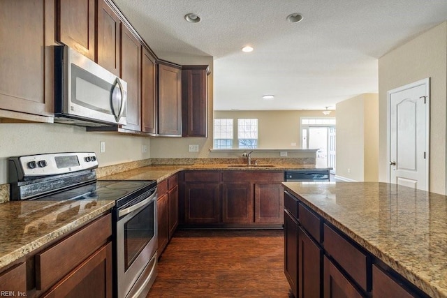 kitchen featuring appliances with stainless steel finishes, light stone counters, and sink