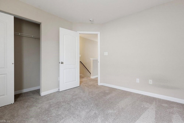 unfurnished bedroom with light carpet and a closet