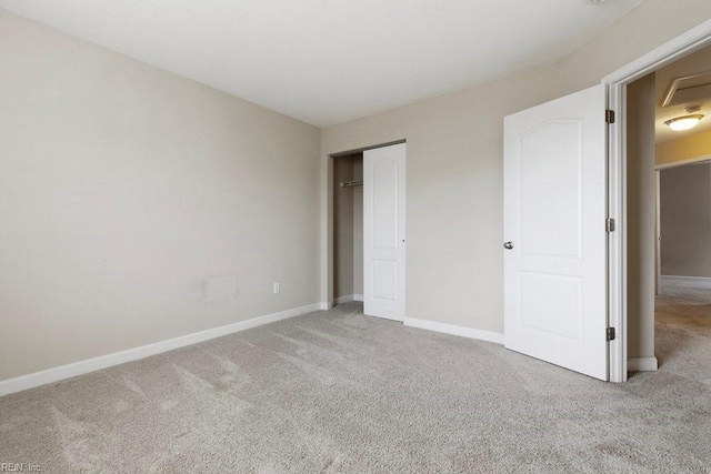 unfurnished bedroom featuring light carpet and a closet