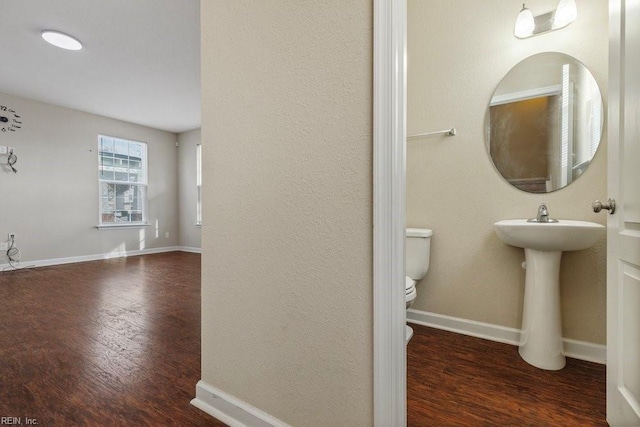 bathroom with toilet, wood-type flooring, and sink