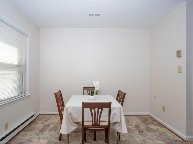 dining room featuring plenty of natural light and a baseboard heating unit