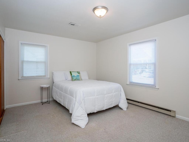 bedroom featuring carpet flooring and a baseboard heating unit