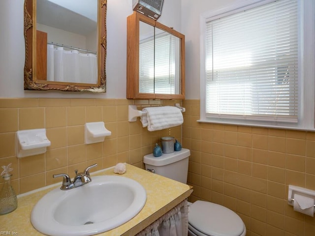 bathroom featuring sink, tile walls, and toilet