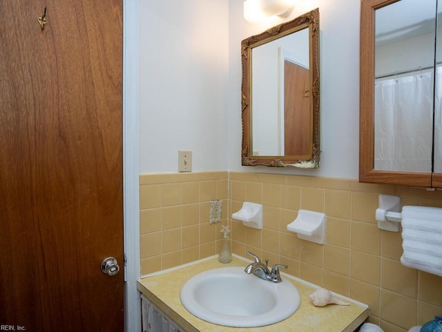 bathroom featuring vanity and tile walls