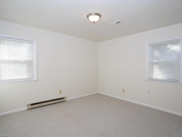 empty room with light carpet and a baseboard heating unit