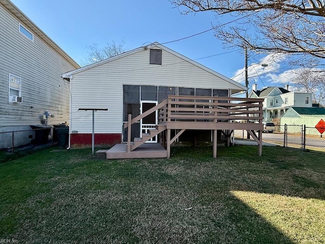 back of house featuring a sunroom, a deck, and a yard