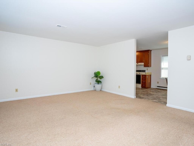 empty room featuring baseboard heating and light carpet