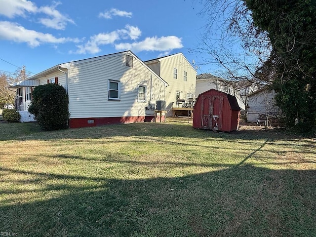 back of house featuring a storage unit, a yard, and central air condition unit