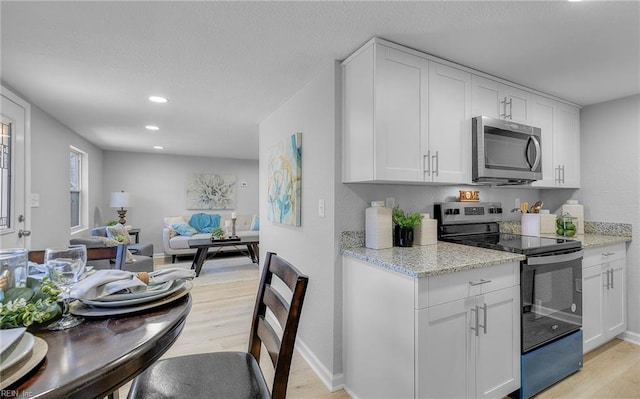 kitchen featuring white cabinetry, light hardwood / wood-style flooring, and stainless steel appliances