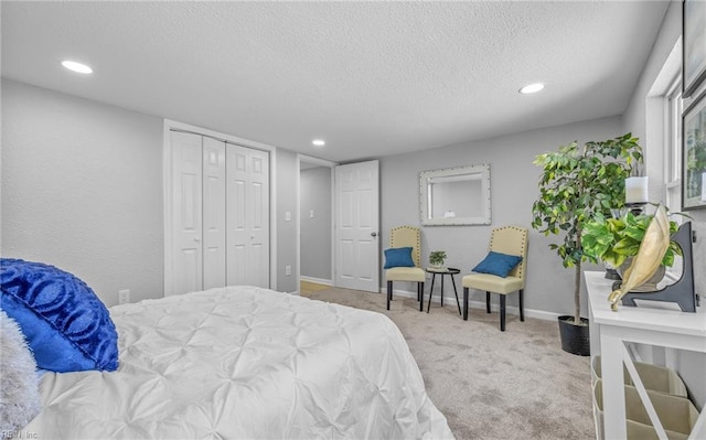 bedroom with light carpet, a textured ceiling, and a closet