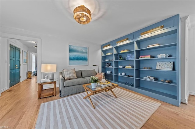 living room featuring built in shelves and light hardwood / wood-style floors